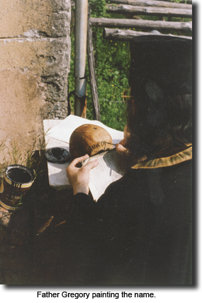 Father Gregory painting the name.