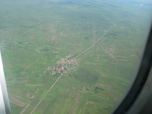 A Photo Taken from a Plane. It shows the poverty of the country. One dirt road
    in and one dirt road out.