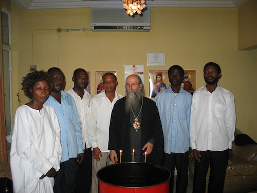 After the baptism, standing in front of the font, left to right, Martha,
    Cosmas, Damian, (who are brothers), Modestos, Patrick and Theophile.