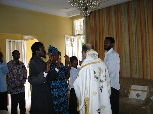 Father Deacon Ambrose and his family with hands raised, renouncing Cyprianism
    and Ecumenism.