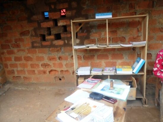 A bookshelf and a table of school books in a classroom