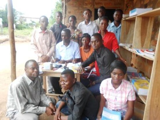 Teachers sitting together by the school bookshelves