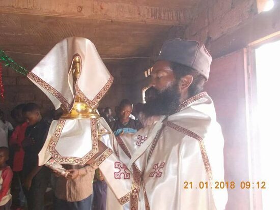 Father Theophile in vestments at the altar, the chalice covered with the veil