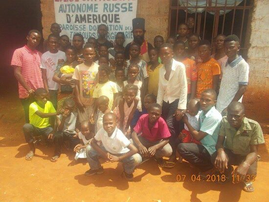The young people and children of the parish in front of the church sign