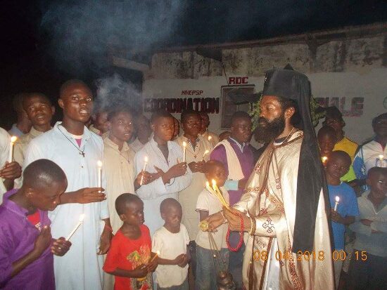 Father Theophile with the faithful holding candles in the Paschal procession