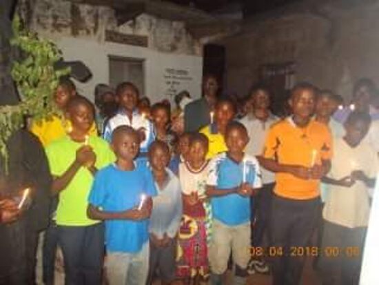 Children and young people holding lit candles by night