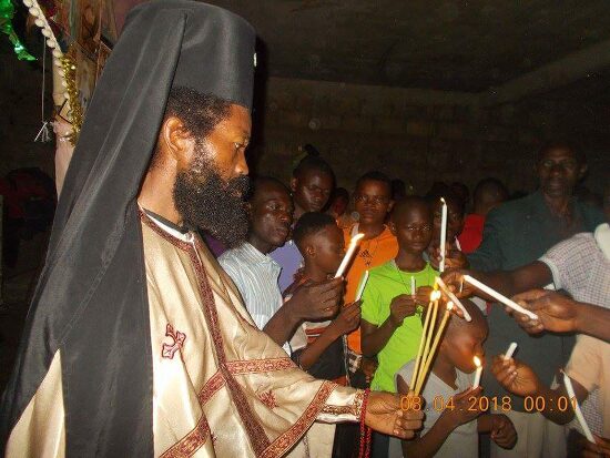 Father Theophile giving the Paschal light to the faithful, who light their candles from his