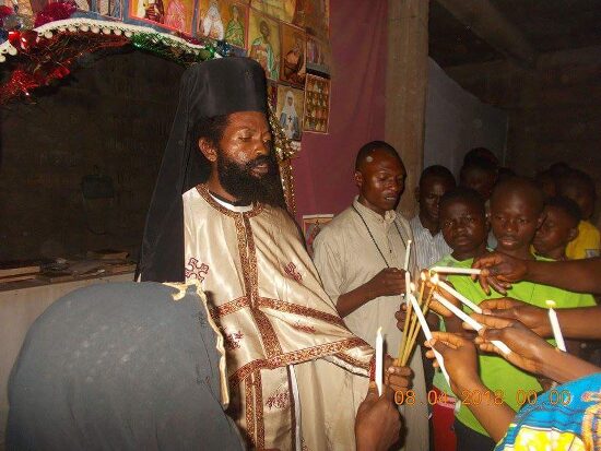 Father Theophile giving the Paschal light to the faithful, who light their candles from his